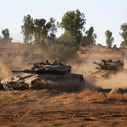 Foto: Izraēlas tanki saceļ smilšu 'vētru' pie robežas ar Sīriju