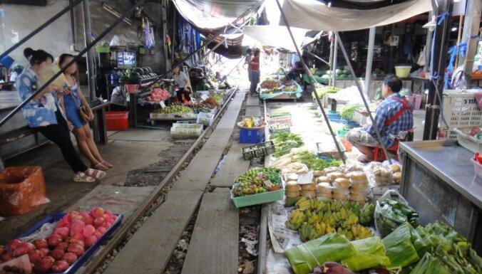 Galvenais, ka andele – vilciens Taizemē, kas brauc cauri tipiskam Āzijas tirgum
