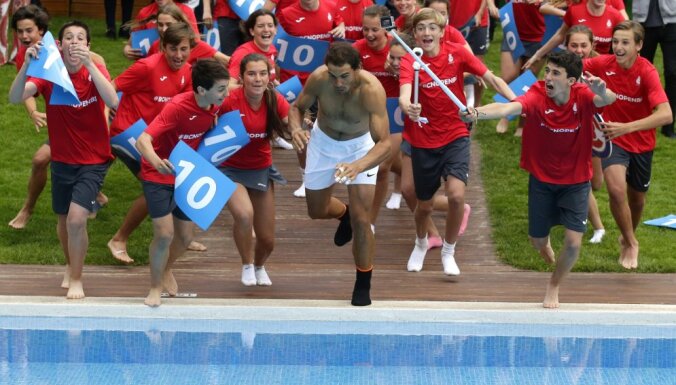 Rafael Nadal of Spain jumps into a swimming pool