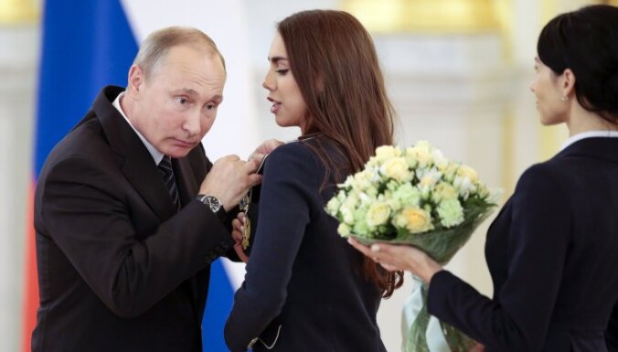 Russian President Vladimir Putin, left, listens to Russia s Margarita Mamun
